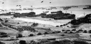Landing ships putting cargo ashore on Omaha Beach, at low tide during the first days of the operation, mid-1944-06 Among identifiable ships present are LST-532 (in the center of the view); USS LST-262 (3rd LST from right); USS LST-310 (2nd LST from right); USS LST-533 (partially visible at far right); and USS LST-524. Note barrage balloons overhead and Army "half-track" convoy forming up on the beach. The LST-262 was one of 10 Coast Guard-manned LSTs that participated in the invasion of Normandy, France.