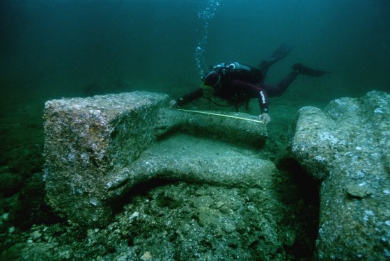 An archaeologist measures the feet of a colossal red granite statue at the site of Heracleion discovered in Aboukir Bay. © Franck Goddio/Hilti Foundation, photo: Christoph Gerigk