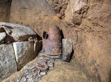 A cuirass known as a “tanko” and preserved in excellent condition, and a stone coffin, left, have been unearthed in Shibushi, Kagoshima Prefecture. (Provided by the Shibushi city education board)