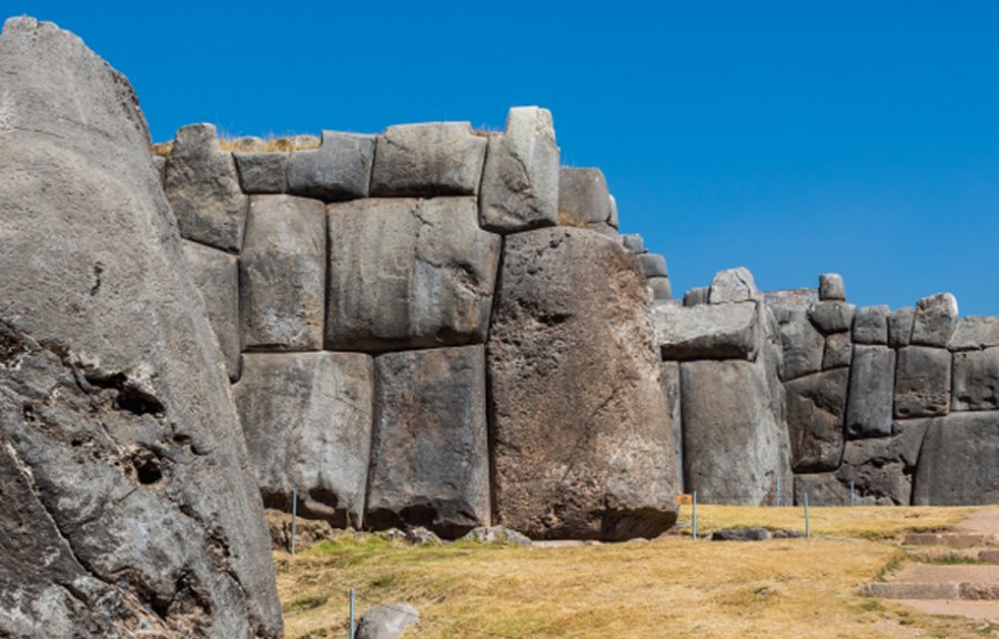 View of a row of corners of the walls of Saksaywaman, a citadel on the northern outskirts of the city of en:Cusco, historic capital of the Inca Empire, today Peru. The first sections of the citadel were first built by the Killke culture about 1100 and expanded by the Inca from the 13th century. The dry stone walls are composed of huge stones, which boulders are carefully cut by workers to fit them together extremely tightly without mortar.